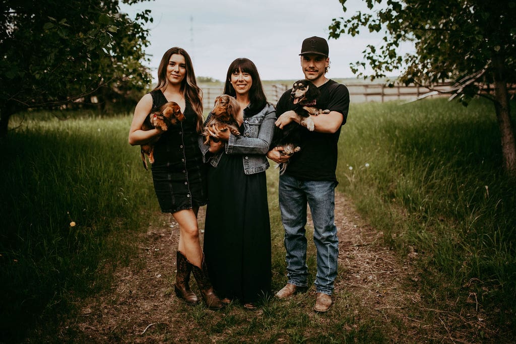 Three people holding puppies in their arms.