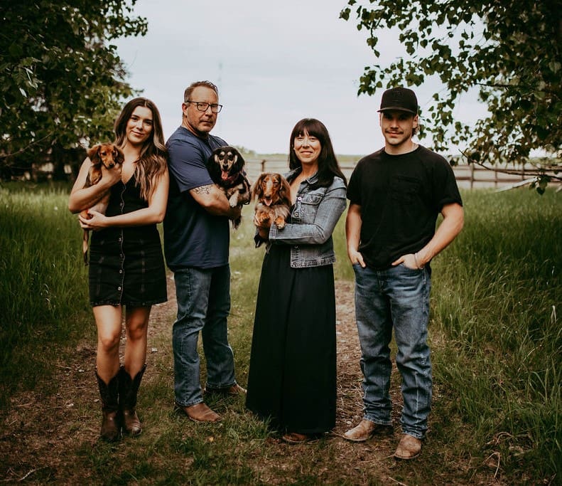 A family posing for a picture in the grass.